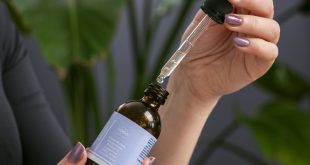 Siero cosmetico con contagocce accanto alle foglie di una pianta