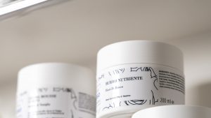 Vasetti e flaconi di una linea cosmetica su mensola