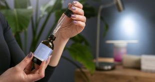Siero cosmetico con contagocce accanto a una pianta