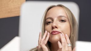 Applicazione di una crema viso davanti allo specchio
